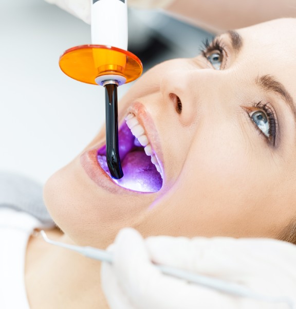 patient whitening teeth at dentist